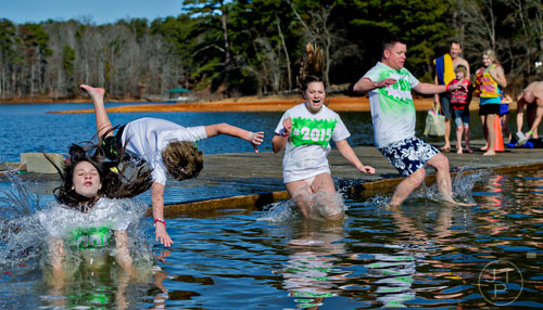Zoie Tisdal (left), Conner Galbraith, his sister Rylie and their father Shane jump into Lake Lanier during the 18th annual Polar Bear Plunge at the Lanier Canoe & Kayak Club in Gainesville on Thursday, January 1, 2015.