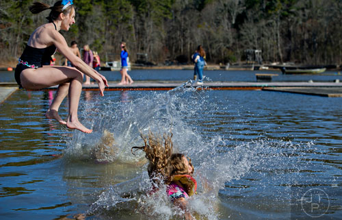 Jenny McClellan (left) follows her daughter Alex (right) and Sherri Kemmerer into Lake Lanier during the 18th annual Polar Bear Plunge at the Lanier Canoe & Kayak Club in Gainesville on Thursday, January 1, 2015. 