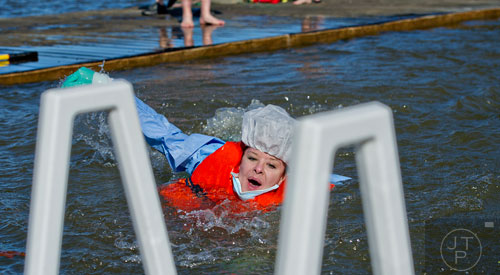 Melissa Gabriel swims towards the ladder after jumping into the 50 degree water of Lake Lanier during the 18th annual Polar Bear Plunge at the Lanier Canoe & Kayak Club in Gainesville on Thursday, January 1, 2015. 