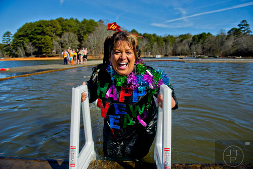 Traci Thomas climbs out of Lake Lanier after jumping into the 50 degree water during the 18th annual Polar Bear Plunge at the Lanier Canoe & Kayak Club in Gainesville on Thursday, January 1, 2015. 