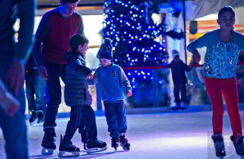 Eduard Schreibmann (left) skates with his son Albert and Patrick Barbulescu at the Southwest Rink at Park Tavern in Atlanta on Saturday, January 3, 2015.