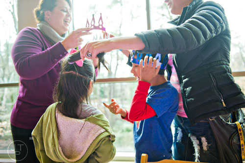 Xiomara Calderon (center left) and her brother Miguel get help putting on their crowns from their mother Rosa (right) and Lynn Aristizabal during the Three Kings Day Festival at the Atlanta History Center on Sunday, January 4, 2015. 