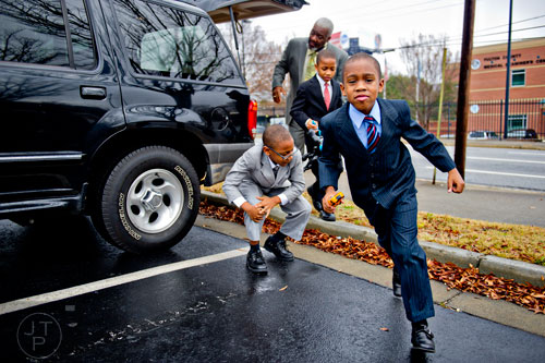 Jimariyo Majette (right), his brothers Jimitrious and Jimarcus and their father Michael climb out of the car in the parking lot of the Fulton County Juvenile Courthouse in Atlanta before Michael and his wife Pam finalize the adoption process of the three brothers on Monday, December 29, 2014. 