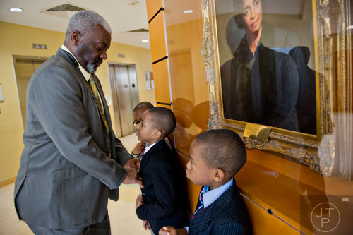 Michael Majette (left) fixes the ties on his sons' Jimitrious, Jimarcus and Jimariyo's suits before heading to Chief Judge Bradley J. Boyd's courtroom to finalize the adoption process with his wife Pam at the Fulton County Juvenile Courthouse in Atlanta on Monday, December 29, 2014.