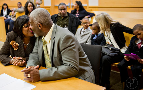 Pam Majette (left) kisses her husband Michael before finalizing the adoption of their three new sons Jimitrious, Jimariyo and Jimarcus at the Fulton County Juvenile Courthouse in Atlanta on Monday, December 29, 2014.
