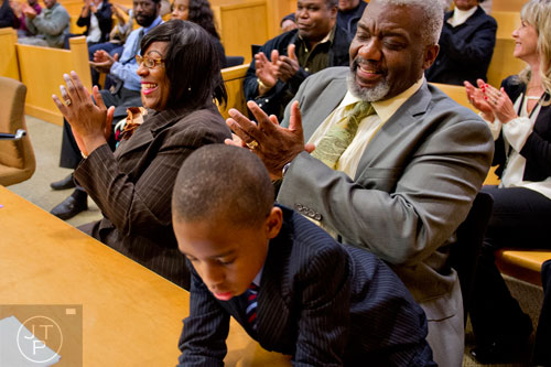 Pam Majette (left) celebrates with her husband Michael and one of their three new sons Mariyo after finalizing the adoption process at the Fulton County Juvenile Courthouse in Atlanta on Monday, December 29, 2014. 