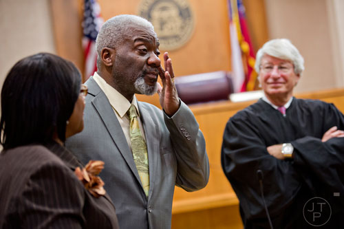 Michael Majette (center) wipes tears from his eyes as he addresses friends and family with his wife Pam (left) and Fulton County Juvenile Court Chief Judge Bradley J. Boyd after finalizing the adoption of their three sons on Monday, December 29, 2014. 