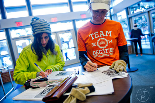 Jessie Bitetti-Griffin (left) and Joy Provost register for the 10th annual Run with the Dogs Frostbite 5k at Decatur High School on Saturday, January 10, 2015. 