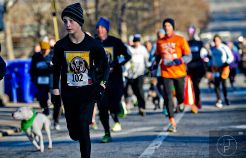 David Putman (left) nears the first turn during the 10th annual Run with the Dogs Frostbite 5k in Decatur on Saturday, January 10, 2015.