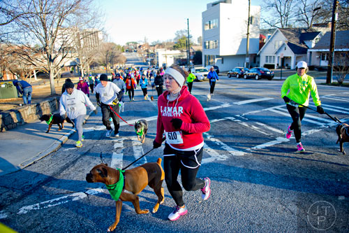 Leah Cook (center) and her dog Reese make the first turn during the 10th annual Run with the Dogs Frostbite 5k in Decatur on Saturday, January 10, 2015. 