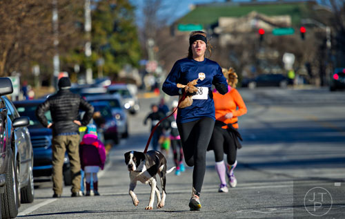 Nora Moore (center) and her dog Tucker near the finish line during the 10th annual Run with the Dogs Frostbite 5k in Decatur on Saturday, January 10, 2015. 