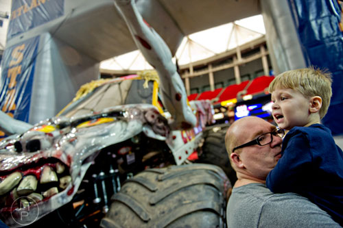 Sam Horner (right) is held by his father Joel as they pass by Zombie during the pit party before the start of Monster Jam at the Georgia Dome in Atlanta on Saturday, January 10, 2015.