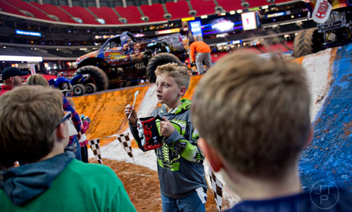 Drew Schena (center) talks to Colin Escobedo (left) and Eli Ollinger as they stand in line to get driver autographs during the pit party before the start of Monster Jam at the Georgia Dome in Atlanta on Saturday, January 10, 2015. 