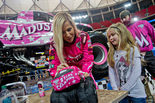 Madusa (left) signs a stuffed truck for Alyssa Whitfield during the pit party before the start of Monster Jam at the Georgia Dome in Atlanta on Saturday, January 10, 2015.