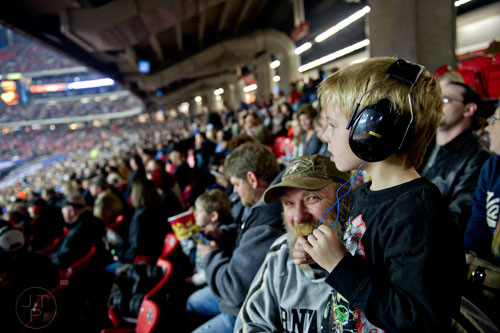 Hunter James Henderson (right) sits next to his grandfather Lamar as they watch Monster Jam at the Georgia Dome in Atlanta on Saturday, January 10, 2015. 
