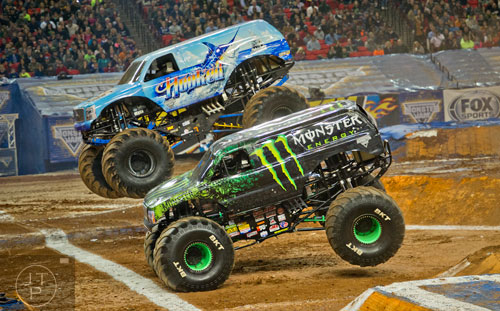 Monster Energy and Hooked race for the finish line during Monster Jam at the Georgia Dome in Atlanta on Saturday, January 10, 2015. 