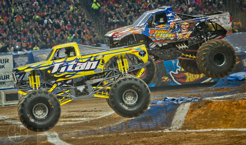 Titan pulls ahead of Stone Crusher during Monster Jam at the Georgia Dome in Atlanta on Saturday, January 10, 2015. 