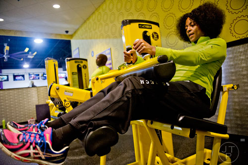 Tammy Clayton uses a leg curl machine as she works out at the Planet Fitness off of Wesley Chapel Rd. in Decatur on Wednesday, January 14, 2015. 