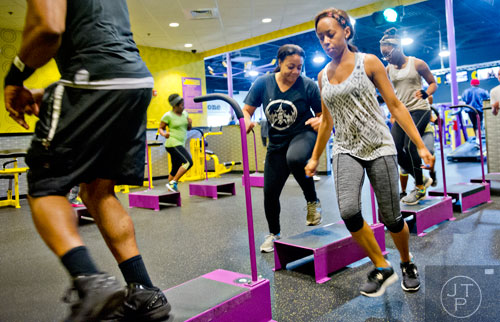 Kristi Skidmore (right) does cardio exercises with classmastes as they work out at the Planet Fitness off of Wesley Chapel Rd. in Decatur on Wednesday, January 14, 2015. 