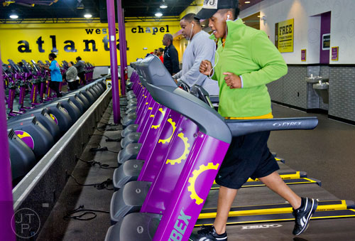 Robin Jarmon (right) and Ronald Shannon use treadmills as they and others work out at the Planet Fitness off of Wesley Chapel Rd. in Decatur on Wednesday, January 14, 2015. 