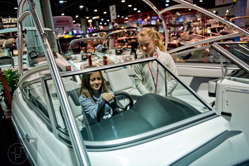 Campbell Stamps (left) and Avery Mize pretend to drive a Yamaha AR210 during the Atlanta Boat Show at the Georgia World Congress Center on Saturday, January 17, 2015. 