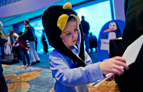 Hayes Bullock (center) looks at a photograph as he walks through the activities during the Party with the Penguins event at the Georgia Aquarium in downtown Atlanta on Saturday, January 17, 2015. 
