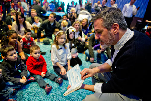Josh Ford (right) reads a story about penguins during the Party with the Penguins event at the Georgia Aquarium in downtown Atlanta on Saturday, January 17, 2015. 
