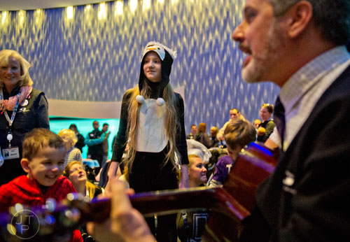 Rachel Pike (center) moves like a penguin as Josh Ford plays on his guitar during the Party with the Penguins event at the Georgia Aquarium in downtown Atlanta on Saturday, January 17, 2015.