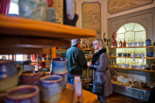 Penny Dobson (right) and her husband Johnnie peruse the pottery on display by the Callawolde Clay Guild during the Callanwolde Arts Festival in Atlanta on Saturday, January 24, 2015. 