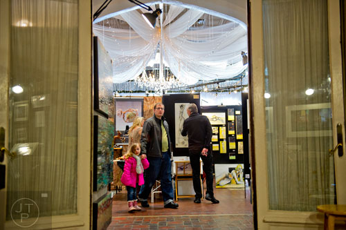Charisma Richter (left) holds her father Grant's hand as they look at the artwork displayed during the Callanwolde Arts Festival in Atlanta on Saturday, January 24, 2015.
