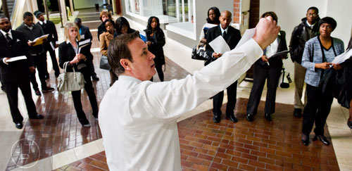 Jim Carter (center) explains the paperwork in his hands to the people waiting in line for the start of the 69th Atlanta Diversity, Professional, Veteran, Collegiate Career Fair at the Cobb Galleria Centre in Atlanta on Thursday, January 29, 2015. 