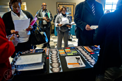 Nichelle Owens (center), Robert Greene and Vernon Greene wait for their opportunity to speak with a representative from Manpower during the 69th Atlanta Diversity, Professional, Veteran, Collegiate Career Fair at the Cobb Galleria Centre in Atlanta on Thursday, January 29, 2015. 