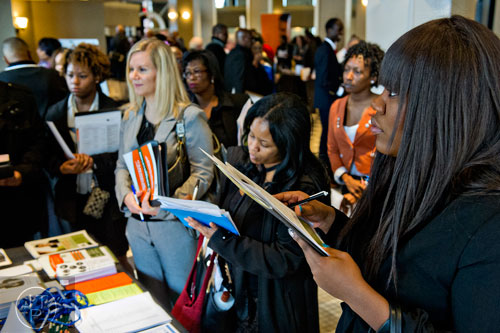 Shavella Stephens (right) fills out a contact form for the Georgia Department of Labor as she looks for a job during the 69th Atlanta Diversity, Professional, Veteran, Collegiate Career Fair at the Cobb Galleria Centre in Atlanta on Thursday, January 29, 2015. 