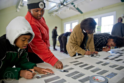 Christopher Lewis (left), Tasalinah Andralliski, Tiana Lewis and Teaheerah Andralliski make nametags before heading out to volunteer during the Decatur Martin Luther King Jr. Service Project weekend on Sunday, January 18, 2015. 