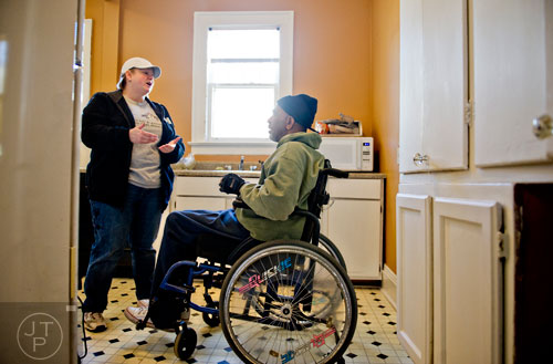 Jennifer Ross (left) talks with Eli Dodson as she and other volunteers make repairs to his home during the Decatur Martin Luther King Jr. Service Project weekend on Sunday, January 18, 2015. 
