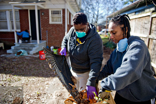 Maketa Colbert (right) and Andrea Parker clean up Annie Harper's back yard during the Decatur Martin Luther King Jr. Service Project weekend on Sunday, January 18, 2015. 
