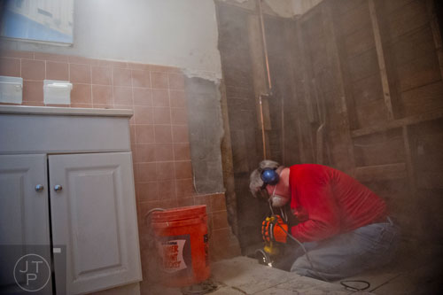 Dust flies everywhere as Phil Houck helps install a new handicap accessible shower in Inez Baughns home during the Decatur Martin Luther King Jr. Service Project weekend on Sunday, January 18, 2015.