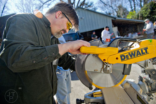 Quinn Eastman uses a saw to cut a piece of wood during the Decatur Martin Luther King Jr. Service Project weekend on Sunday, January 18, 2015. 