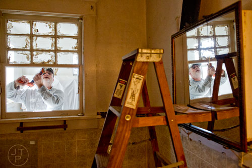 Charles Absher seals a window in Buelah Rosser's bathroom during the Decatur Martin Luther King Jr. Service Project weekend on Sunday, January 18, 2015. 