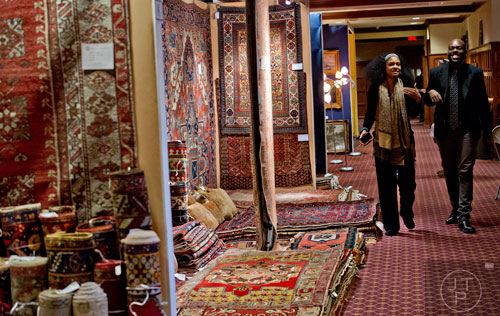 Cindy Smith (left) and Trevon Bennett walk past a display of different rugs during the Cathedral Antiques Show at the Cathedral of St. Philip in Atlanta on Saturday, February 7, 2015. 