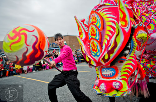 Christopher Lu (left) leads a paper dragon around the crowd during the Chinese Lunar New Year celebration in Chamblee on Saturday, February 21, 2015. 