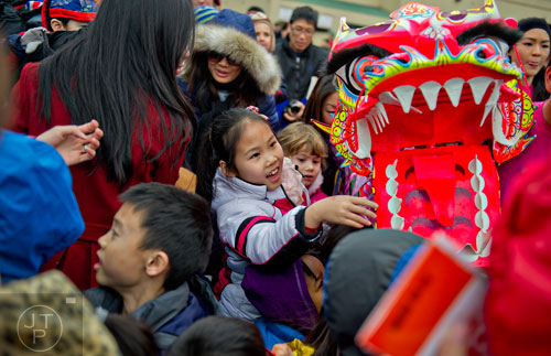 Zichun Yang (center) places a donation into a paper dragon's mouth after a performance during the Chinese Lunar New Year celebration in Chamblee on Saturday, February 21, 2015.