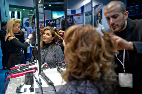 Suzanne Whitfield (center) has her hair styled by Giovanni Dapp during the 2015 Bronner Bros. International Beauty Show at the Georgia World Congress Center in Atlanta on Sunday, February 22, 2015. 