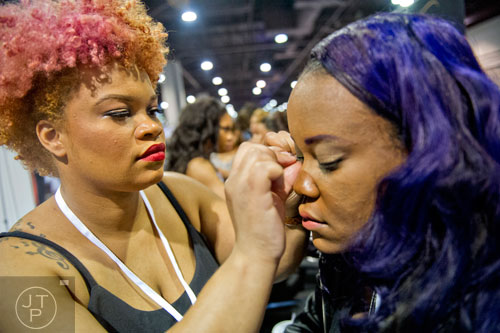 Ruby Brown (left) applies a set of eyelashes to Amelia Johnson's eyelids during the 2015 Bronner Bros. International Beauty Show at the Georgia World Congress Center in Atlanta on Sunday, February 22, 2015. 