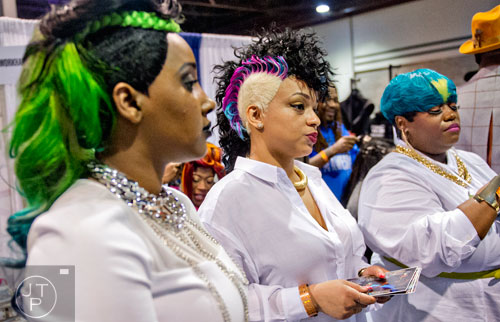 LeQundal Brown (right), Kenoyia Lyons and Terrica Lee hand out flyers to the crowd passing by during the 2015 Bronner Bros. International Beauty Show at the Georgia World Congress Center in Atlanta on Sunday, February 22, 2015. 