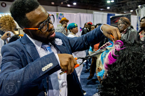 Dominque Holloway (left) styles Shauriah Bogan's hair during the 2015 Bronner Bros. International Beauty Show at the Georgia World Congress Center in Atlanta on Sunday, February 22, 2015. 