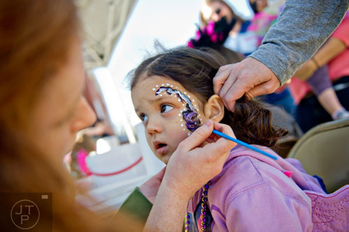 Maya Deodhar (center) gets her face painted as she prepares for the start of the Mead St. Mardi Gras parade in Decatur on Saturday, February 7, 2015.