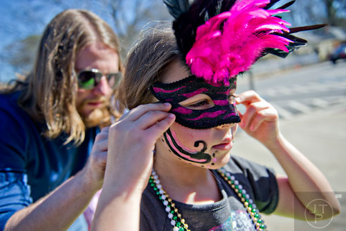 Madison Harvey (right) gets help putting on her mask from her step father Johnny Langford as they prepare for the start of the Mead St. Mardi Gras parade in Decatur on Saturday, February 7, 2015.