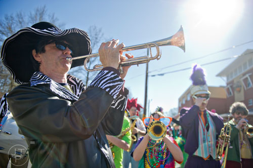 John Moredock (left) blasts his trumpet to start off the Mead St. Mardi Gras parade in Decatur on Saturday, February 7, 2015.