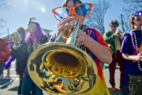 Jake Cooper (center) plays the trumpet as he marches down Oakview Rd. in Decatur during the Mead St. Mardi Gras parade on Saturday, February 7, 2015.